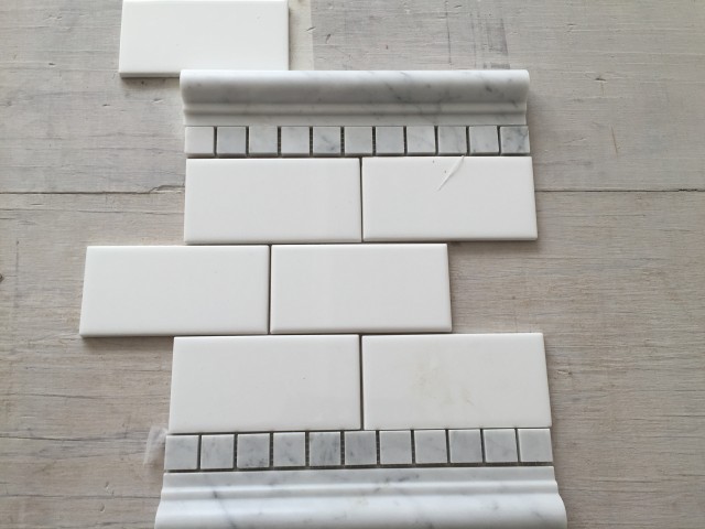 The detail band in the master shower will be separated by a cararra marble chair rail and a row of 1" cararra tiles.